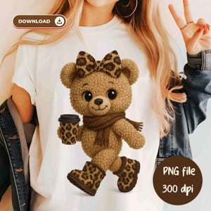 May include: White t-shirt featuring a cartoon teddy bear with a bow, scarf, and boots, all with a leopard print design. The bear is holding a coffee cup with a matching leopard print. The image also includes the text "PNG file 300 dpi".