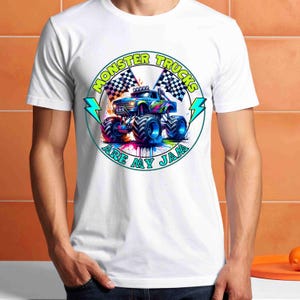 Puede incluir: Camiseta blanca con un gr&aacute;fico colorido de un monster truck y el texto "MONSTER TRUCKS ARE MY JAM" en un dise&ntilde;o circular. El dise&ntilde;o incluye banderas a cuadros y rayos.
