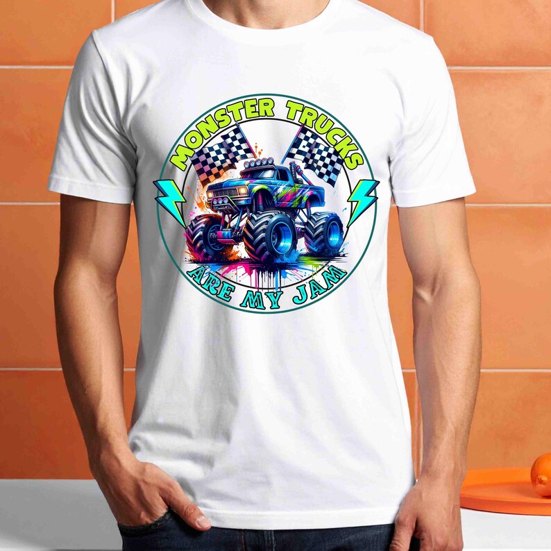 Puede incluir: Camiseta blanca con un gr&aacute;fico colorido de un monster truck y el texto "MONSTER TRUCKS ARE MY JAM" en un dise&ntilde;o circular. El dise&ntilde;o incluye banderas a cuadros y rayos.