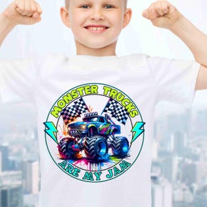 Puede incluir: Camiseta blanca con un gr&aacute;fico colorido de un monster truck, banderas a cuadros y el texto "MONSTER TRUCKS ARE MY JAM" en un dise&ntilde;o circular. El monster truck es azul, con neum&aacute;ticos grandes y un vibrante efecto de salpicaduras de pintura.