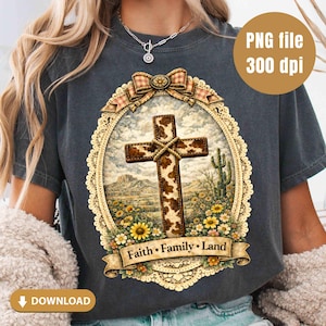 May include: Dark gray t-shirt featuring a detailed cross design with a cowhide pattern, set against a desert landscape with sunflowers and a cactus. The design includes the text "Faith • Family • Land" and a decorative bow.