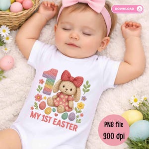 Könnte beinhalten: Ein Baby in einem weißen Body mit einer bunten "1" und einer Hasen-Grafik, umgeben von Blumen und Ostereiern. Der Text "MY 1ST EASTER" ist darunter gedruckt. Das Baby trägt ein rosa Stirnband. Babykleidung zum Thema Ostern.