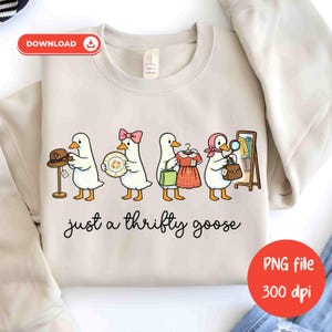 May include: Cream-coloured sweatshirt with a cartoon design of four geese, each holding an item: a hat, a plate, a dress, and a handbag. The phrase "just a thrifty goose" is written below the geese in a handwritten style font.
