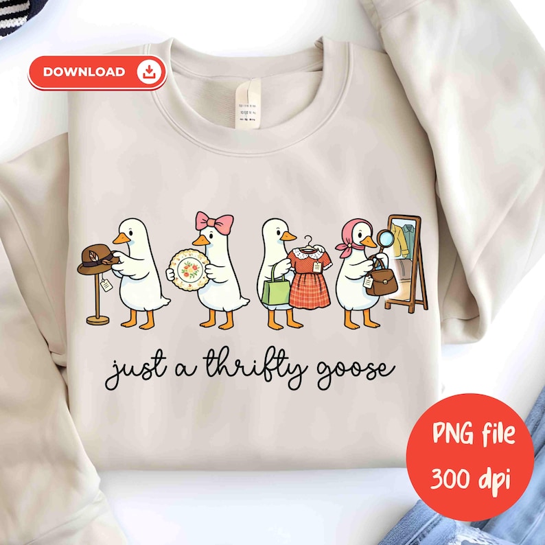 May include: Cream-coloured sweatshirt with a cartoon design of four geese, each holding an item: a hat, a plate, a dress, and a handbag. The phrase "just a thrifty goose" is written below the geese in a handwritten style font.
