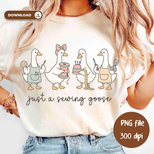 以下が含まれることがあります： クリーム色のTシャツ。4羽のガチョウが裁縫道具を持っているイラスト。ガチョウの下には「just a sewing goose」と書かれています。右下には「PNG file 300 dpi」と書かれた茶色の円があります。