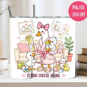May include: A white tumbler featuring a cartoon goose in a pink robe holding a baby goose and a bottle. The tumbler has the text "STRING CHEESE MAMA" and is decorated with other cartoon elements like a sofa, toys, and drawings.