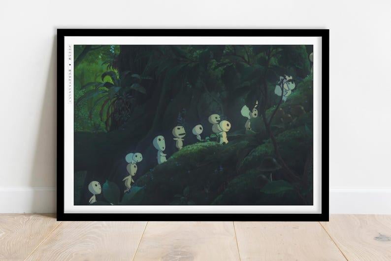 May include: A framed print depicting a forest scene with several small, white, humanoid figures with round heads. The figures are walking on a mossy surface, surrounded by lush green foliage. The print is in a black frame.