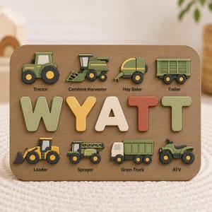 May include: A rectangular wooden puzzle board featuring the name WYATT in large, colorful letters. The board includes eight farm vehicle cutouts labeled Tractor, Combine Harvester, Hay Baler, Trailer, Loader, Sprayer, Grain Truck, and ATV.