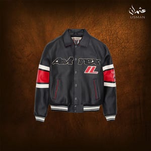 Puede incluir: Chaqueta de cuero negra con el texto "Avi rex" en blanco y un dise&ntilde;o de rayas rojas y blancas en las mangas. La chaqueta tiene una parte delantera abotonada y cuello y pu&ntilde;os acanalados.