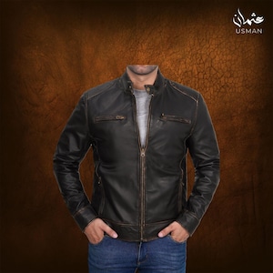 May include: Black leather jacket with a zip-up front, two chest pockets, and a stand-up collar. The jacket has a distressed finish with brown accents. The brand name "USMAN" is visible in the upper right corner.