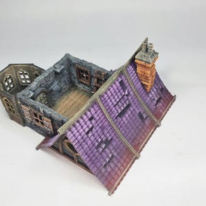 以下が含まれることがあります： 紫色のタイルの屋根、レンガの煙突、石壁を備えたミニチュアファンタジーの建物。モデルには複数の窓と木の床があります。建物は古く、風化したように見えるように設計されています。