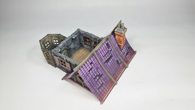 以下が含まれることがあります： 紫色のタイルの屋根、レンガの煙突、石壁を備えたミニチュアファンタジーの建物。モデルには複数の窓と木の床があります。建物は古く、風化したように見えるように設計されています。