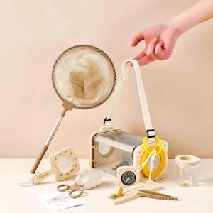 May include: A collection of children's outdoor exploration tools, including a bug catcher, net, magnifying glass, compass, and tweezers. The set features natural wood tones, beige, and yellow accents, perfect for nature study and insect observation.