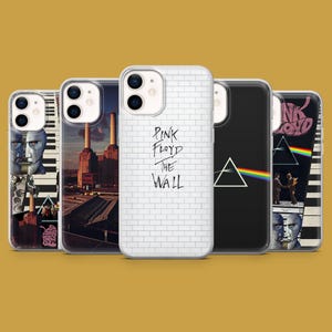May include: Five phone cases with Pink Floyd album art. Designs include a white brick wall with text, a black case with a prism and rainbow, and other album cover graphics. The cases are displayed against a mustard yellow background.