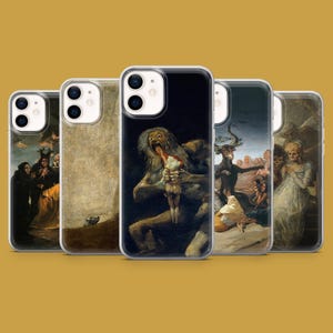 May include: A collection of five iPhone cases featuring classic art prints. The cases display various paintings with dark, dramatic themes, including figures and scenes with a historical and artistic style. The cases are arranged against a solid yellow-brown background.