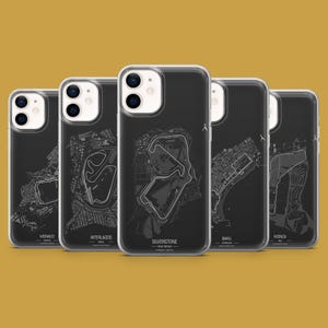 Peut inclure: Cinq coques de téléphone noires affichant des circuits de course blancs. Chaque coque représente un circuit différent : Monaco, Interlagos, Silverstone, Bakou et Monza. Fond jaune moutarde.