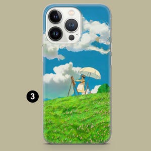 May include: A phone case featuring a vibrant illustration of a person painting on a grassy hill under a bright blue sky with fluffy white clouds. The artist is holding a parasol. The case has a clear border and a number 3 in a black circle.