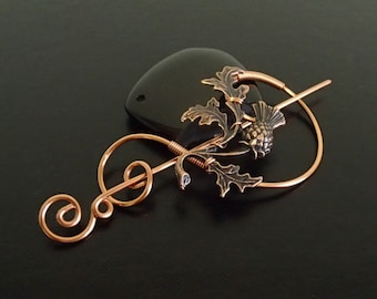 May include: A copper wire hair pin with a thistle design. The pin is shaped like a treble clef and has a small black stone attached to the end.