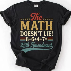 May include: A black short-sleeved t-shirt featuring the text The MATH DOESN'T LIE! 8+6+4+7= 25th Amendment in a vintage-style font with red, yellow, and teal colours. The design includes five small stars above the word The and a teal curved line.