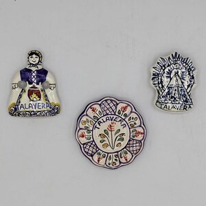 Può includere: Tre calamite Talavera in ceramica. Una raffigura una donna in abiti tradizionali, un'altra un motivo floreale e la terza un'icona religiosa. Tutti sono dipinti in blu, bianco, rosso e giallo.