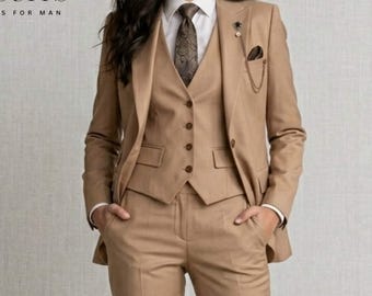 Pode incluir: Um fato bege de três peças com gravata e lenço de bolso a condizer. O fato inclui blazer, colete e calças. O logótipo "APEX SUITS FORMAL SUITS FOR MAN" é visível. A pessoa está a usar uma camisa branca.
