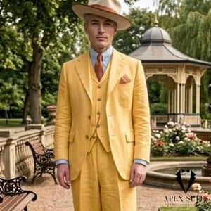 Op de afbeelding: Een gele driedelige pak met bijpassende hoed en stropdas. Het pak bestaat uit een jasje, vest en broek. De hoed is beige met een bruine band. Het pak wordt gedragen met een lichtblauw overhemd en een bruine stropdas.