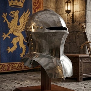 Op de afbeelding: Een gepolijste zilveren ridderhelm, onderdeel van de "Tournament Series", tentoongesteld op een houten standaard. De helm heeft geklonken details en een vizieropening. Op de achtergrond een wandtapijt met een gouden griffioen en kroon, en een zwaard.
