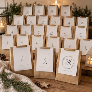 Könnte beinhalten: Ein Adventskalender bestehend aus vierundzwanzig braunen Papiertüten, die in Reihen angeordnet sind. Jede Tüte hat ein weißes Etikett mit einer handgeschriebenen Zahl von 1 bis 24. Die Etiketten zeigen kleine Zeichnungen von Sternen, Herzen und Kränzen.