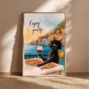 Peut inclure: Impression aquarelle d'un chat noir savourant une pizza et du vin à une table surplombant une ville côtière. Le texte "Enjoy your life" est écrit au-dessus du chat. L'œuvre est encadrée dans un cadre en bois.