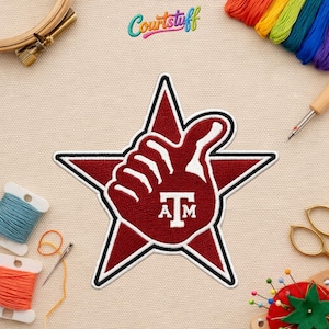 May include: A maroon and white patch in the shape of a star with a thumbs-up hand gesture. The hand has the letters "A" and "M" inside. The patch is surrounded by black and white stitching. The word "Courtstuff" is in the top right corner.