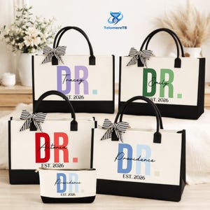 May include: A collection of personalized canvas tote bags and a matching cosmetic bag. The bags are white with black trim and handles, featuring names and the title "DR." in various colors. Each bag has a striped bow.