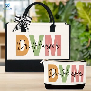 May include: A white tote bag and matching cosmetic bag. Both bags have black accents and the text "DVM Dr. Harper" in orange, green, and pink. The tote bag has black handles and a black and white striped bow.