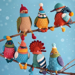 Peut inclure: Huit ornements d'oiseaux crochetés aux couleurs vives, perchés sur une branche marron sur fond bleu clair. Chaque oiseau présente des détails uniques, tels que des chapeaux et des écharpes, avec des couleurs rouge, orange, bleu et vert.
