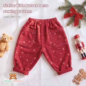 May include: Stellar Kids Barrel Pants sewing pattern sizes: 6m - 4y. Red pants with a white snowflake print, an elastic waistband, and two large front pockets. The pants feature cuffed hems and are displayed with a teddy bear and nutcracker.
