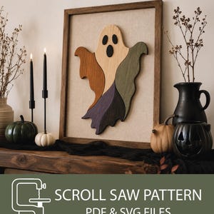 Puede incluir: Una pieza de arte de pared de madera enmarcada que presenta una silueta de fantasma multicolor compuesta por segmentos de madera clara, marrón, verde y morado. El fantasma tiene ojos y boca ovalados negros. El texto inferior dice SCROLL SAW PATTERN PDF & SVG FILES.