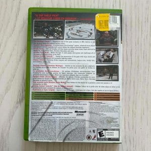 May include: A green Xbox game case featuring the game title and a hockey scene. The back of the case has game details, including "Intense Contact Controls" and "Always Online" features. The ESRB rating is visible.