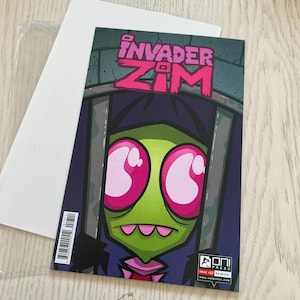 May include: Invader Zim comic book, issue #1, featuring a green alien with large pink eyes behind bars. The comic's title is in pink and purple, with the Oni Press logo at the bottom. The comic is on a white backing board.