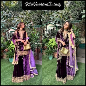 May include: Two women wearing matching purple velvet outfits with gold embroidery. The outfits include a long-sleeved top, wide-leg pants, and a shawl. Each woman carries a gold handbag. The text "NikFashionGalaxy" is at the top.