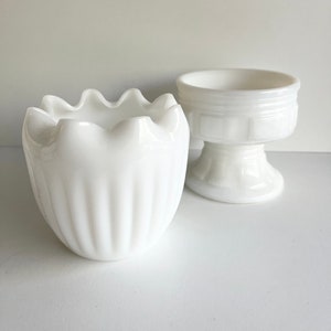 Peut inclure: Deux bols en verre de lait blanc. Un bol a un motif cannelé et un bord festonné. L'autre bol a un piédestal.