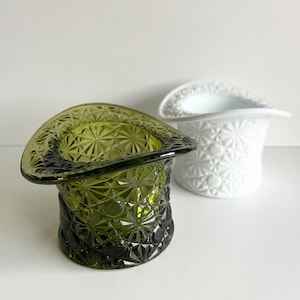 May include: Two vintage glass hat-shaped trinket dishes. One is green and the other is white. Both have a diamond pattern.