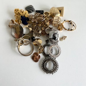 Puede incluir: Una colecci&oacute;n de pendientes vintage de oro y plata, que incluye un par de pendientes grandes de aro con dise&ntilde;os intrincados, un par de pendientes de aro m&aacute;s peque&ntilde;os con cuentas negras y un par de pendientes colgantes con un dise&ntilde;o floral.