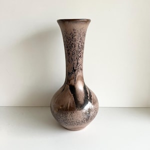 以下が含まれることがあります： 丸みを帯びたベースと細長い首を持つ装飾的な花瓶。花瓶は、茶色と黒の色合いの斑点模様で、光沢のある仕上がりです。約25cmの高さの、装飾的な家の装飾品です。