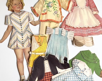 May include: A vintage paper doll with various outfits. The doll wears a striped dress. Other outfits include a yellow floral top and trousers, a red gingham dress, a blue dress, and a green jacket.