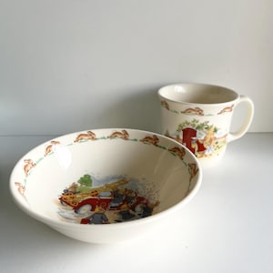 May include: A white ceramic bowl and mug with a bunny rabbit design. The bowl features a red fire truck with bunnies putting out a fire. The mug has a bunny rabbit design with a red fire hydrant.