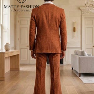 May include: A rust-colored suit with a textured pattern. The suit includes a two-button jacket and flared trousers. The image also shows the logo for Matty Fashion Tuxedo Shop.