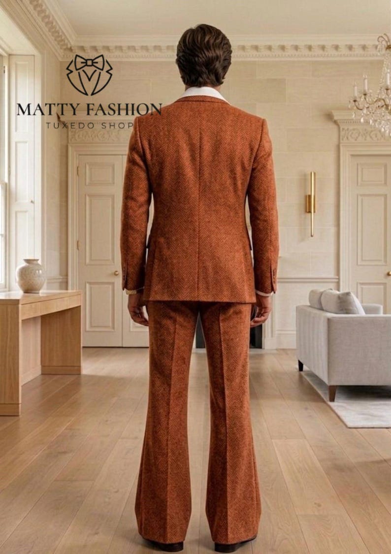 May include: A rust-colored suit with a textured pattern. The suit includes a two-button jacket and flared trousers. The image also shows the logo for Matty Fashion Tuxedo Shop.