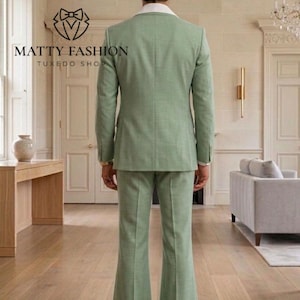 May include: A light green suit with a white collared shirt is displayed. The suit jacket and pants are a matching shade of green. The pants have a flared design. The text "MATTY FASHION TUXEDO SHOP" is visible in the image.