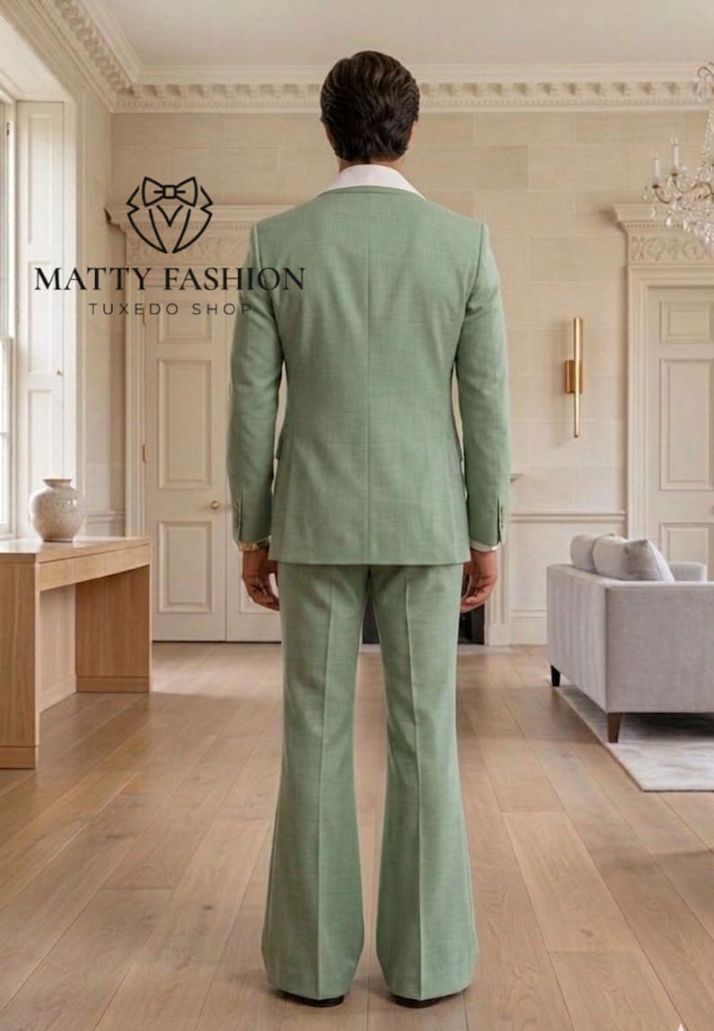 May include: A light green suit with a white collared shirt is displayed. The suit jacket and pants are a matching shade of green. The pants have a flared design. The text "MATTY FASHION TUXEDO SHOP" is visible in the image.