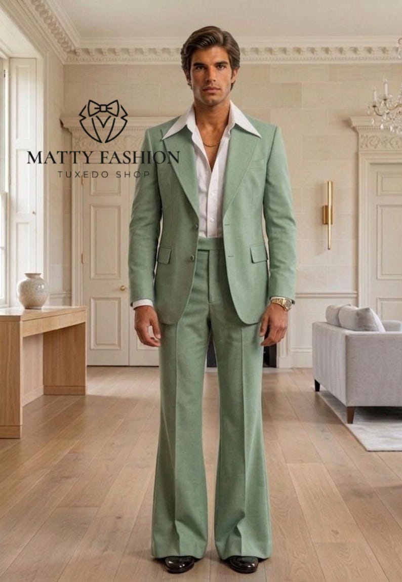 May include: A light green suit with a wide lapel jacket and flared pants. The suit is paired with a white dress shirt. The image includes the text "MATTY FASHION TUXEDO SHOP".