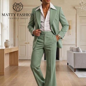 May include: A light green suit with a wide lapel jacket and flared pants. The suit is paired with a white collared shirt. The image includes the text "MATTY FASHION TUXEDO SHOP".